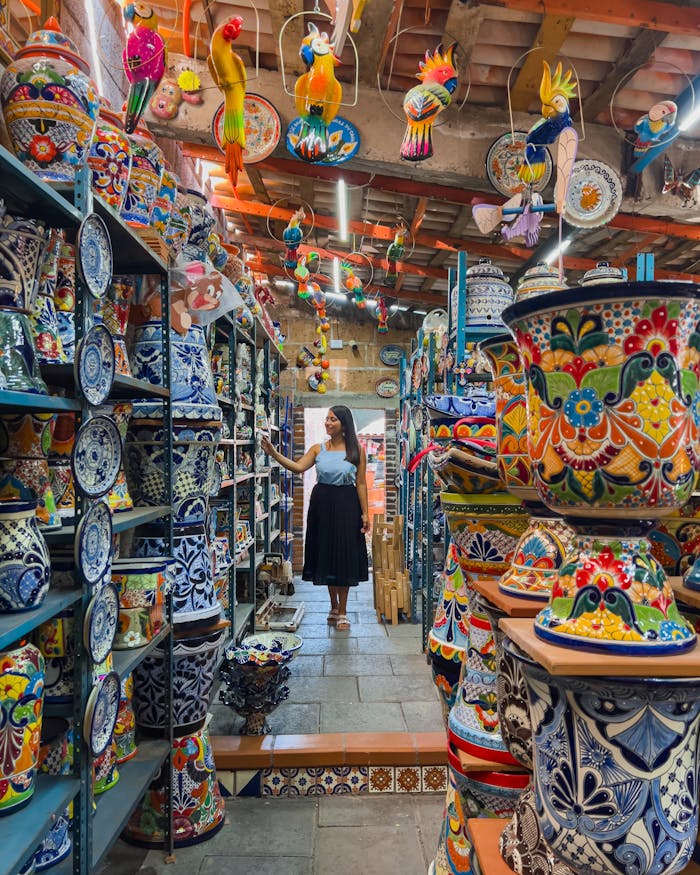 services-06 A woman shopping amidst vibrant ceramic pottery in Cholula, Mexico.