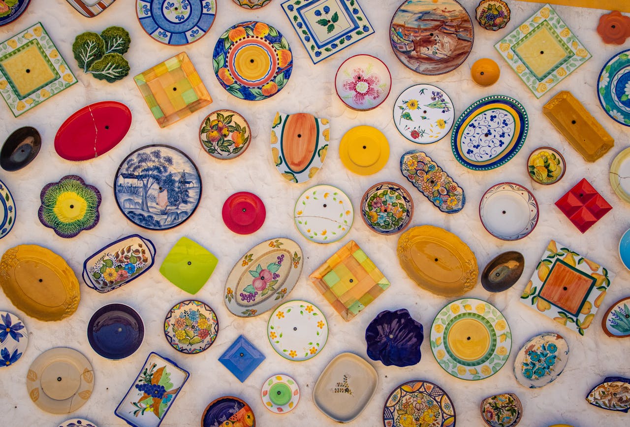 home-hero Colorful array of decorative ceramic plates exhibited in Faro, Portugal.