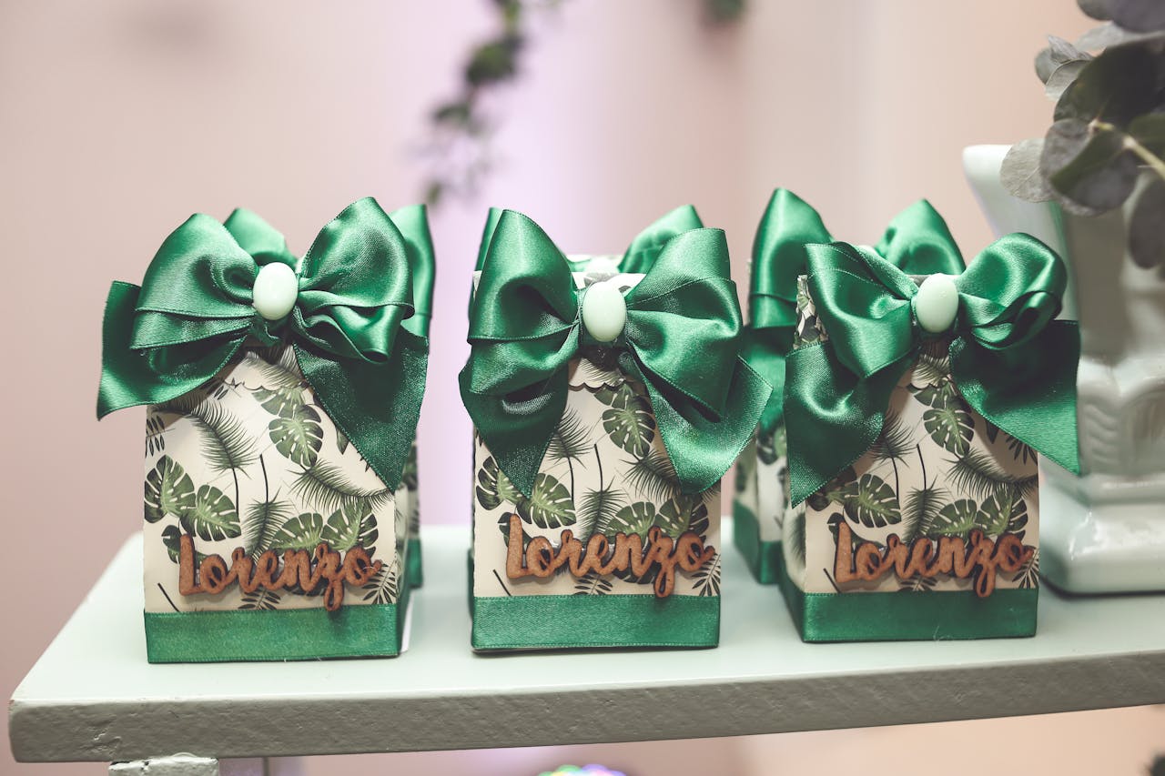 services-03 Set of decorated gift boxes with green bows and tropical leaf pattern, labeled 'Lorenzo'.